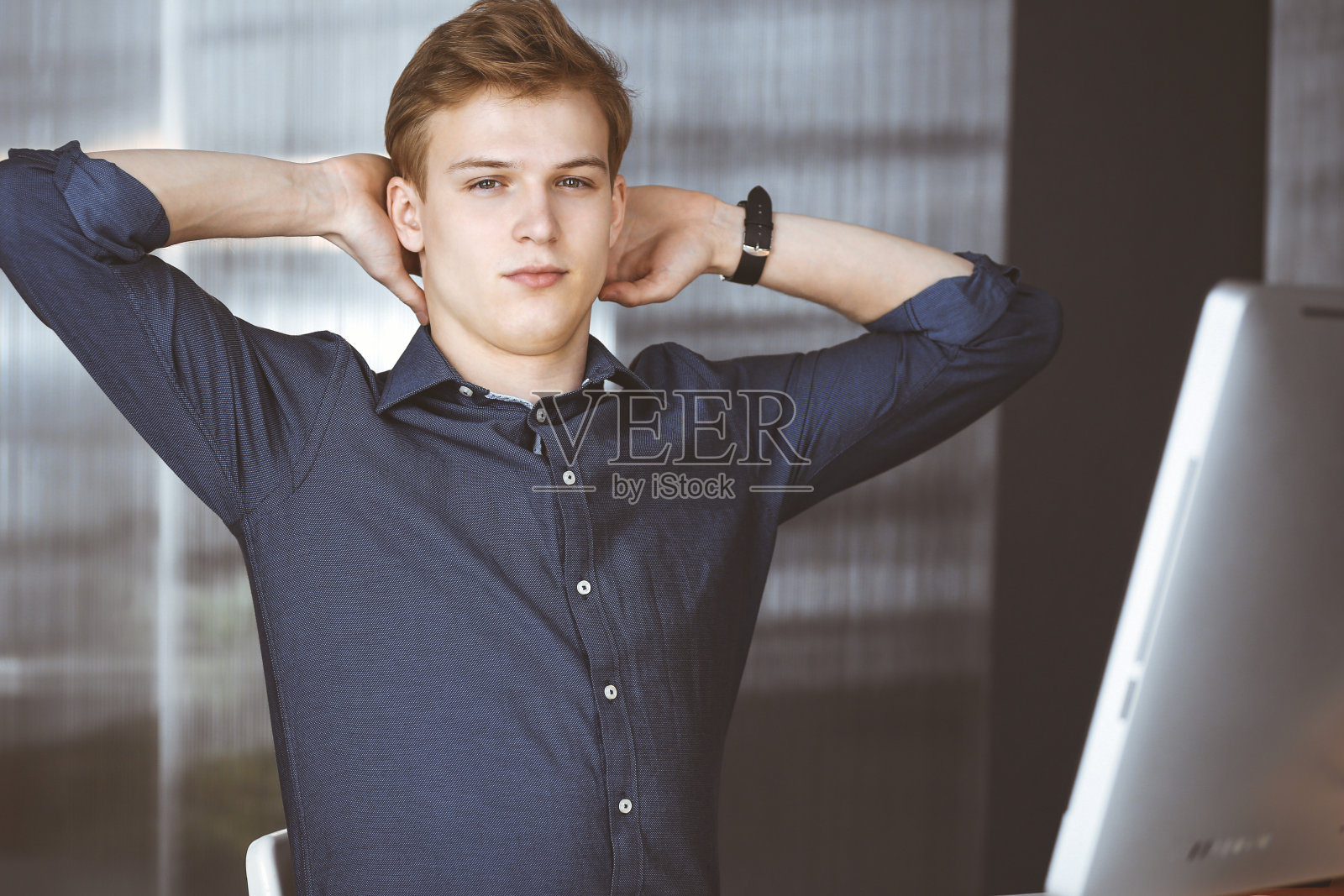 年轻的金发商人和程序员在电脑上辛苦工作后伸出手。创业通向成功照片摄影图片