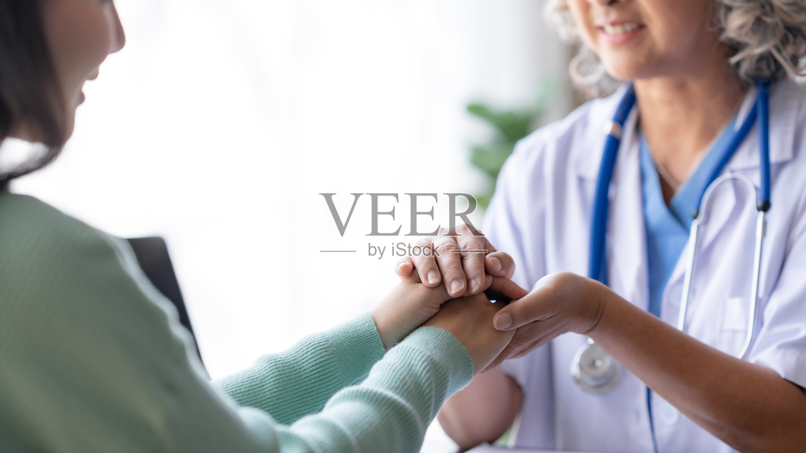 一名亚洲女医生正在安慰和咨询病人，以减轻对疾病的担忧。照片摄影图片