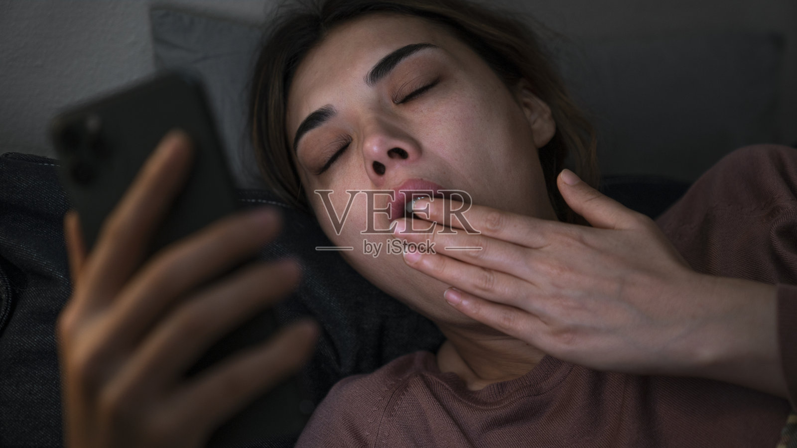 女人晚上躺在床上玩手机照片摄影图片