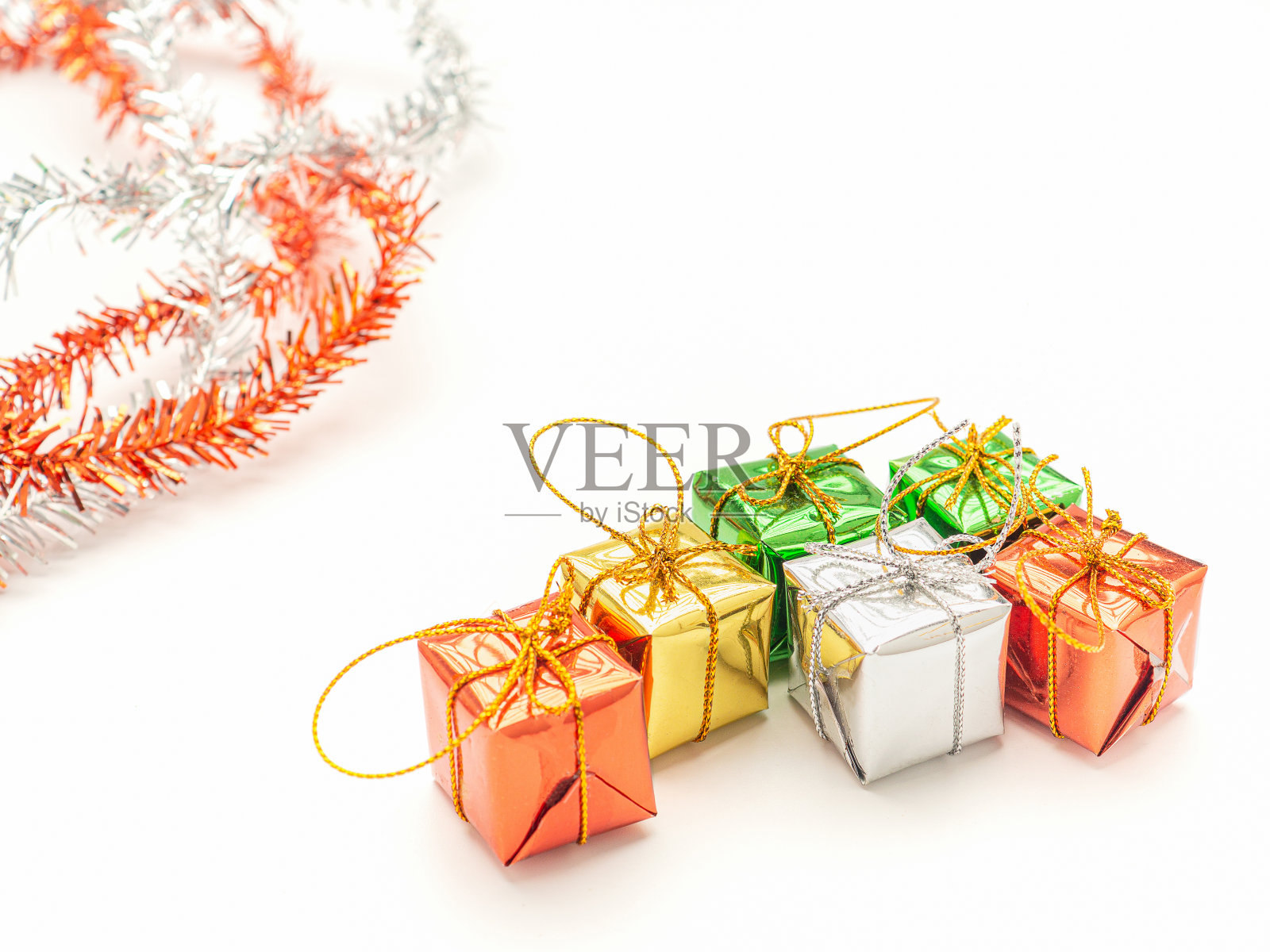 白色背景上的部分圣诞树和彩色礼盒。照片摄影图片