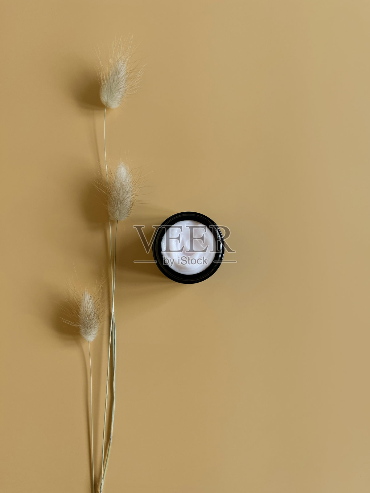 护肤霜在粉彩的背景与干花。天然美容产品的概念。俯视图和复制空间平铺。天然化妆品概念。照片摄影图片