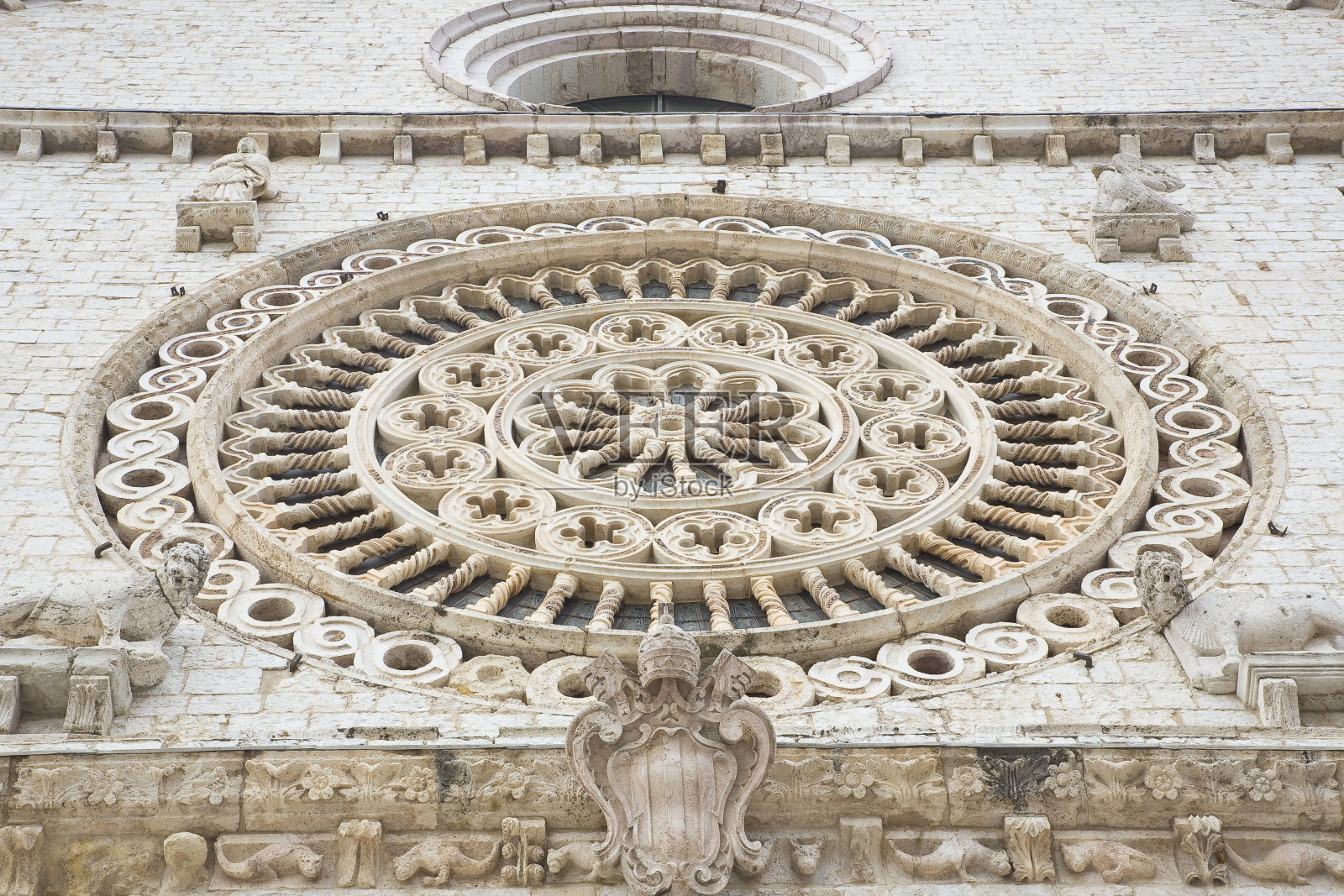 中世纪意大利玫瑰窗对着石墙-意大利-阿西西圣弗朗西斯科教堂照片摄影图片