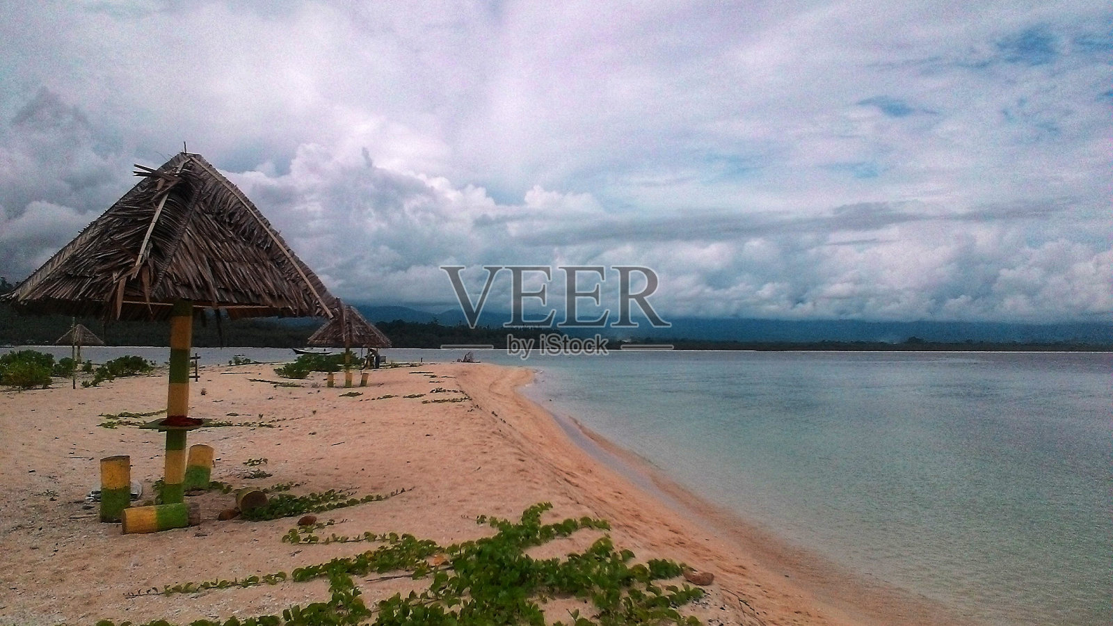 美丽的海滩，多云的天空和白色的沙滩照片摄影图片