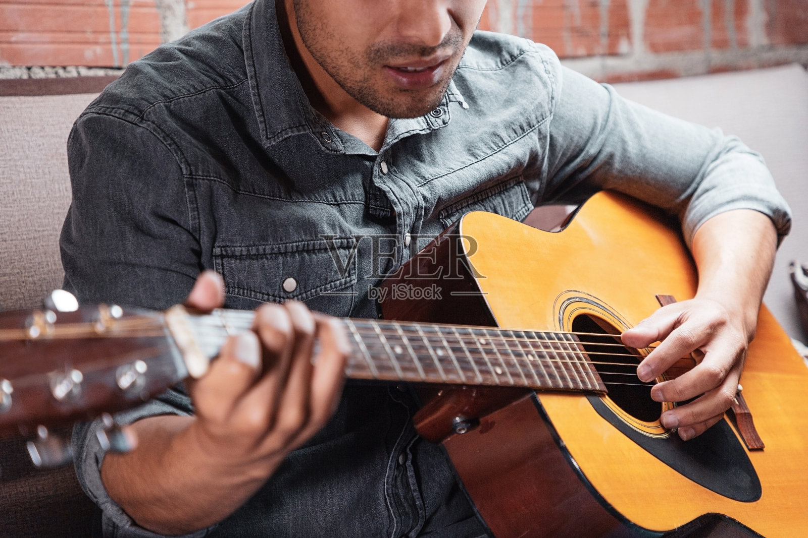 男人在家拿着原声吉他，弹唱。音乐作曲家的概念。吉他手照片摄影图片
