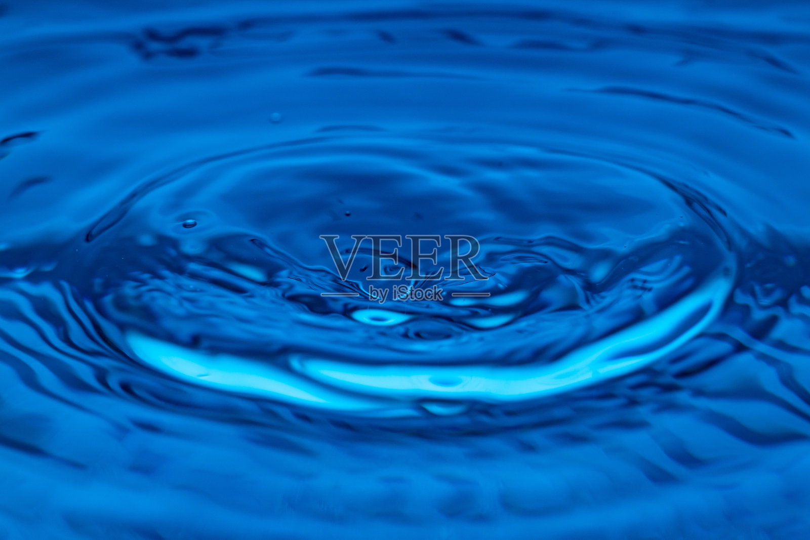 水滴飞溅在蓝色的玻璃上照片摄影图片