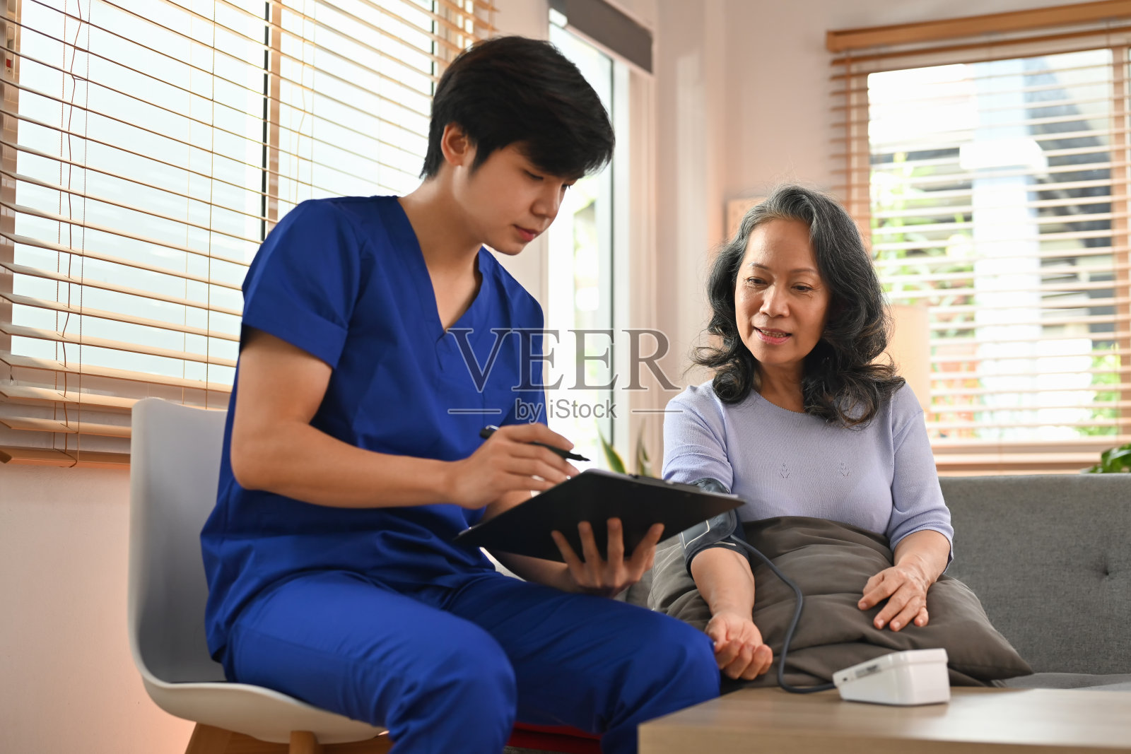 年轻医生向老年女病人展示阳性检测结果。保健和援助概念。照片摄影图片