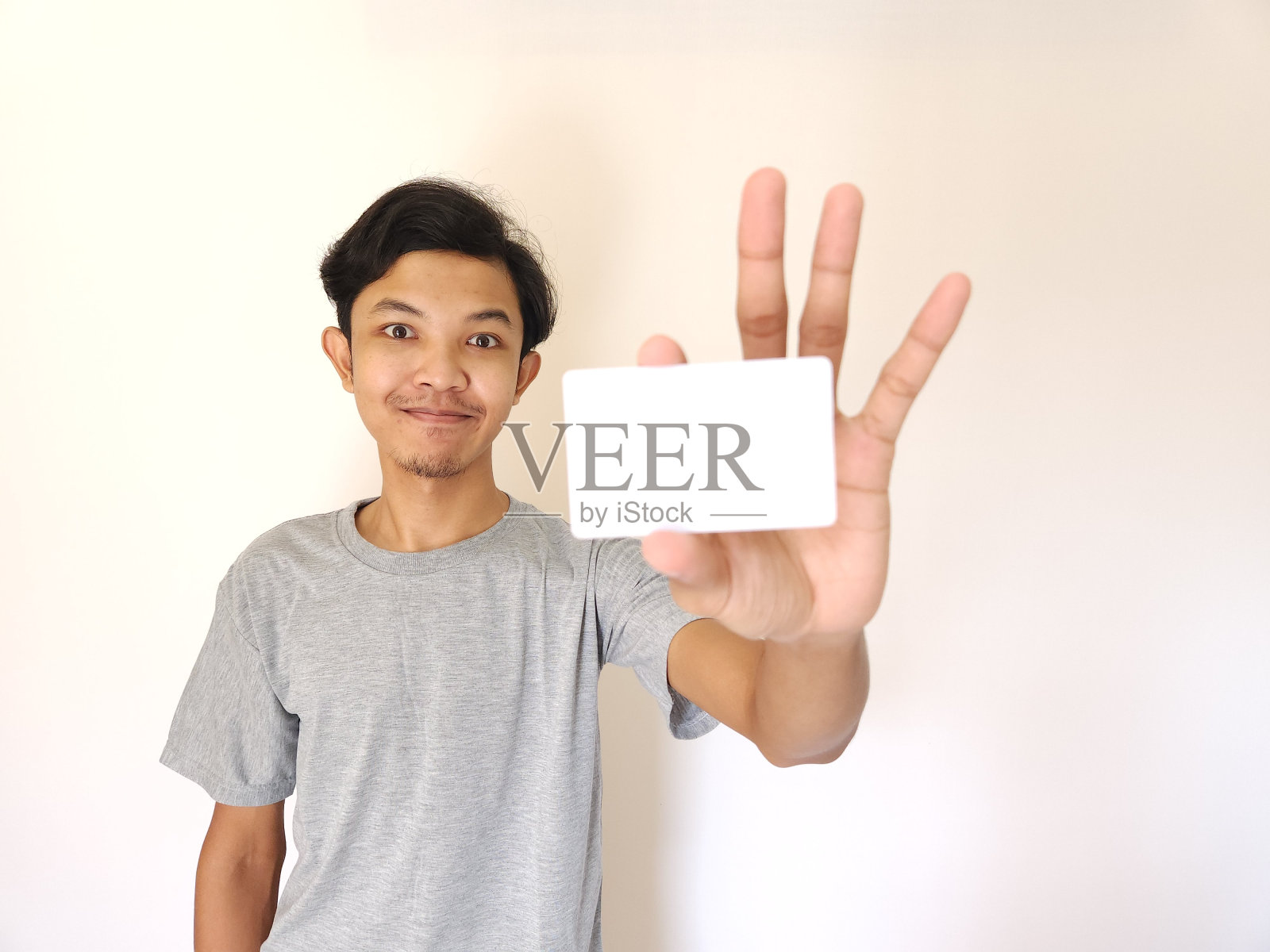 男子展示近距离的空牌，专注于牌。照片摄影图片