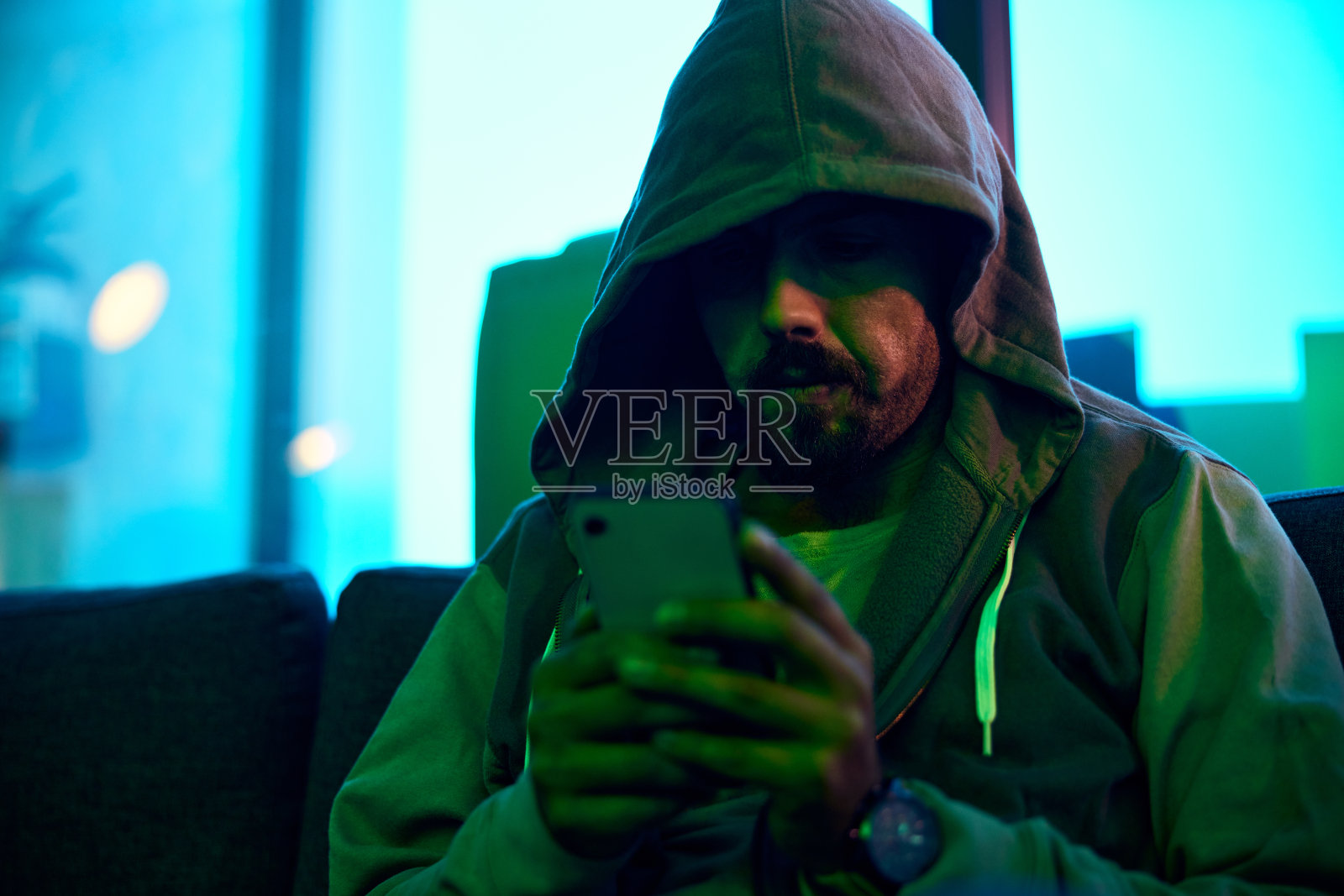 手机、夜间帽衫或霓虹黑客入侵在线数据库软件、网站服务器或男子密码钓鱼。绿色勒索软件开发者，网络安全编程和程序员安装恶意软件代码照片摄影图片