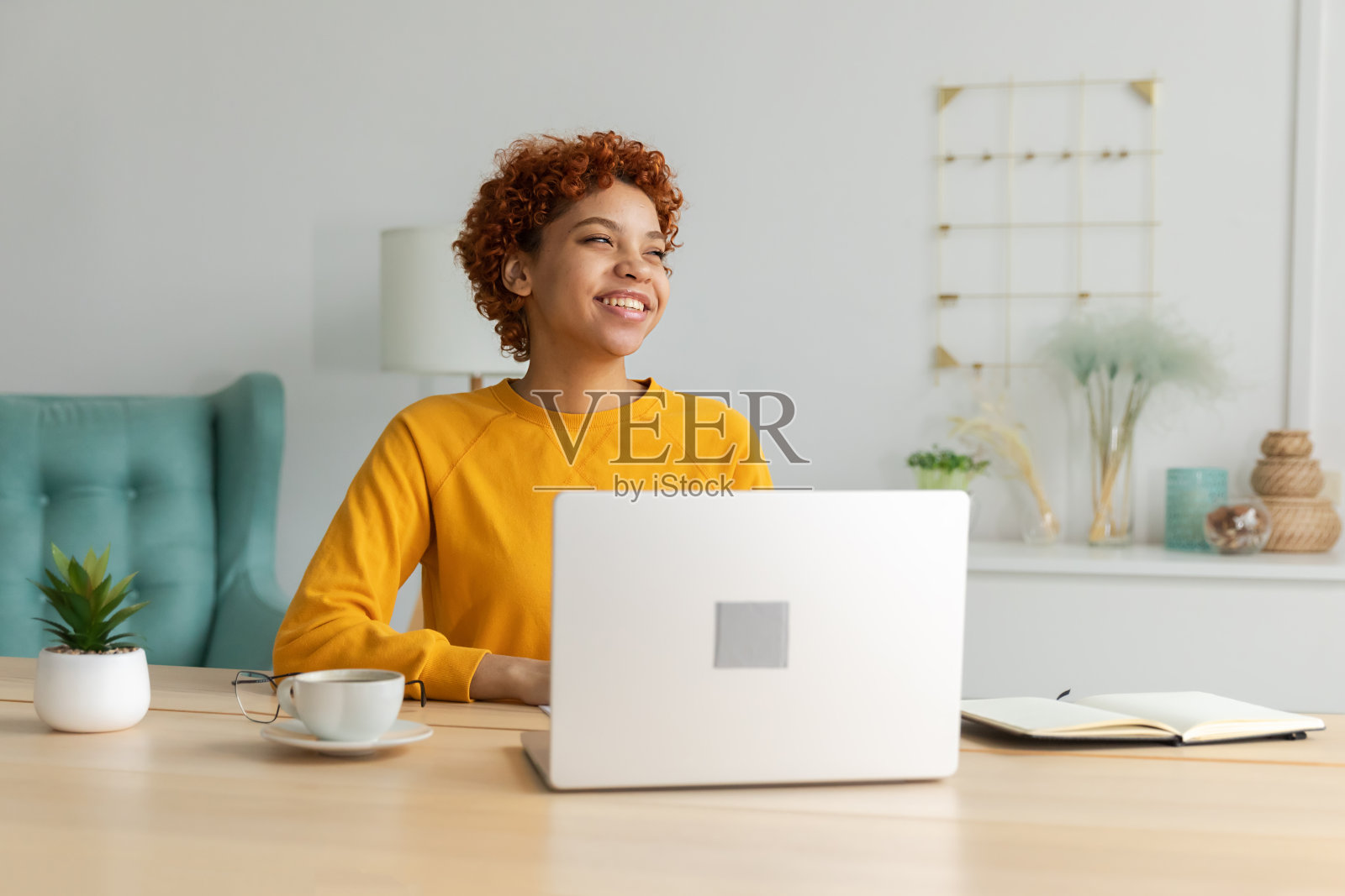 非裔美国女孩使用笔记本电脑在家庭办公室看屏幕打字聊天阅读写作电子邮件。年轻女子正在进行虚拟会议在线聊天视频电话会议在家工作学习照片摄影图片