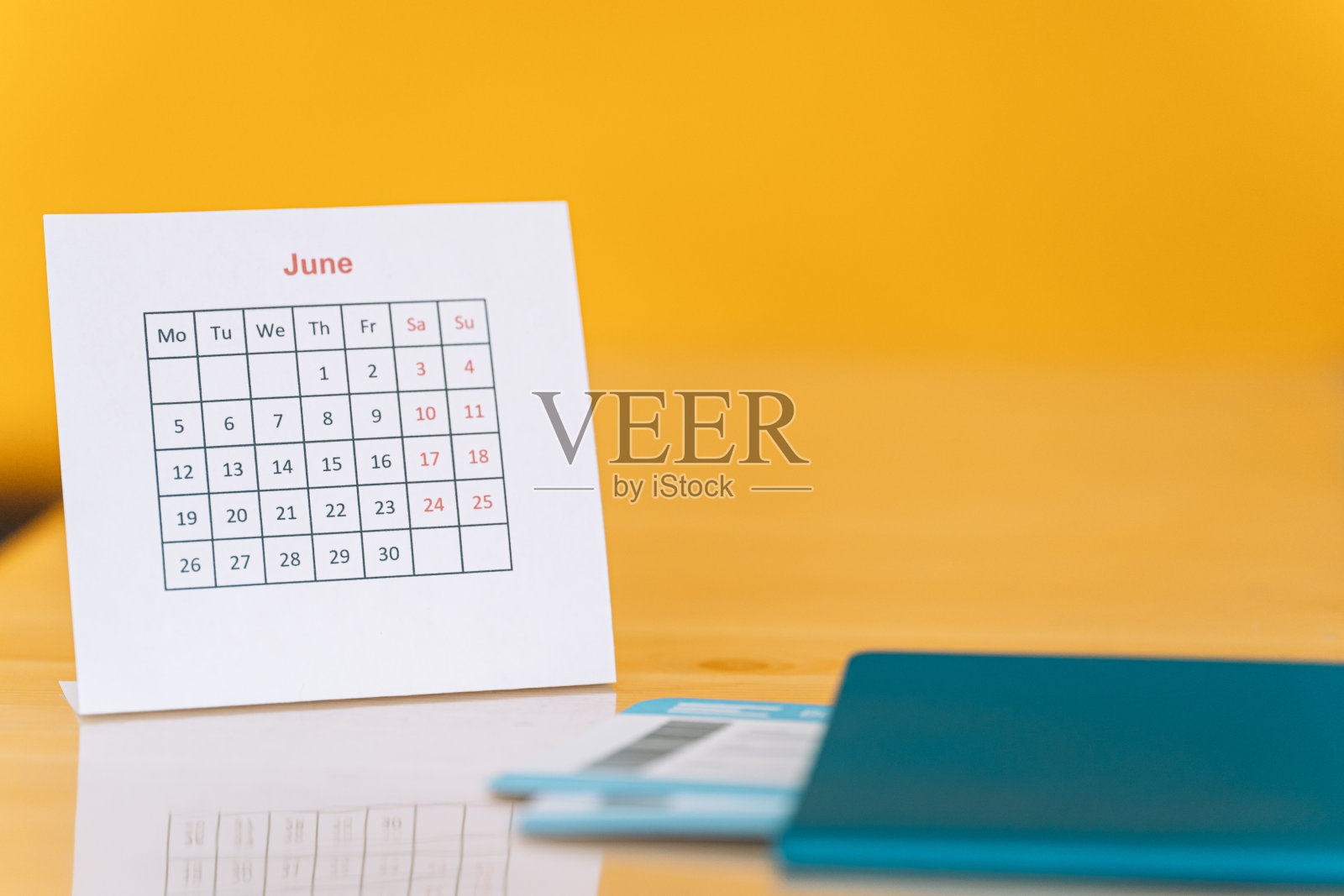 机票在护照旁边以六月日历为黄色背景照片摄影图片