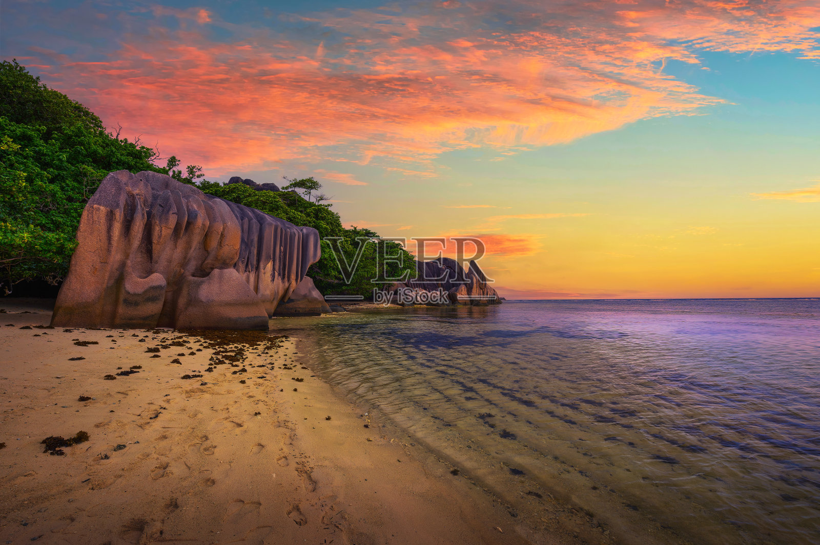 在塞舌尔的拉迪格岛，Anse Source D'argent海滩上的彩色日落照片摄影图片