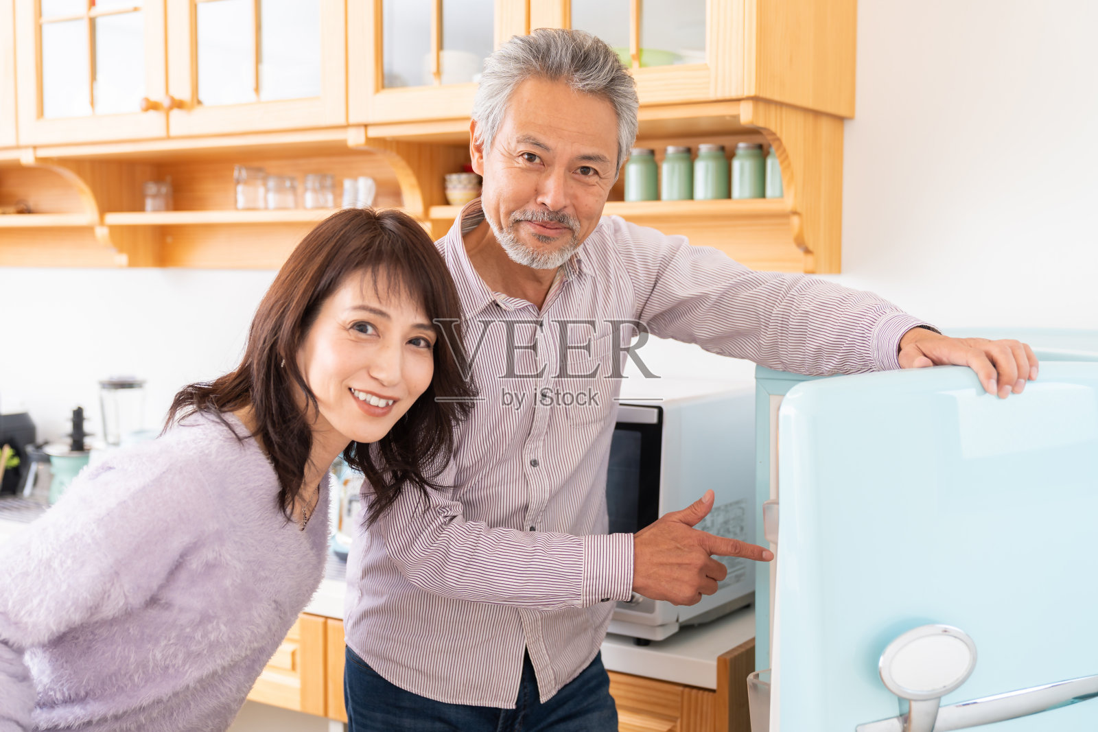 会做饭的老年夫妇，冰箱照片摄影图片