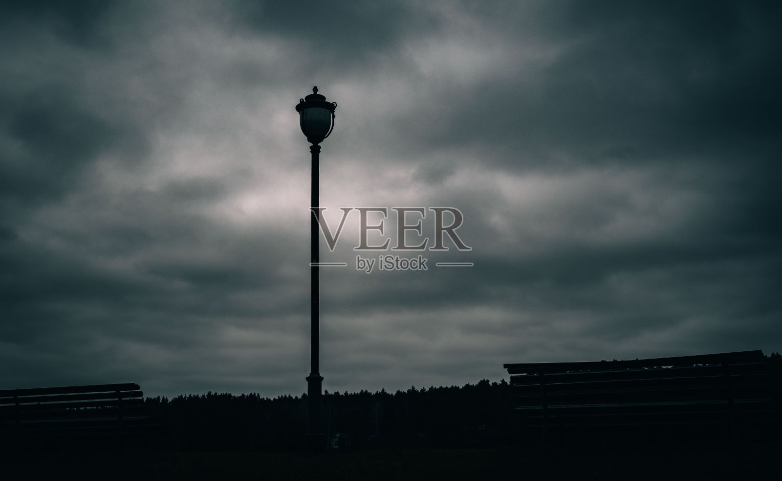 多云的天空映衬出街灯的剪影照片摄影图片