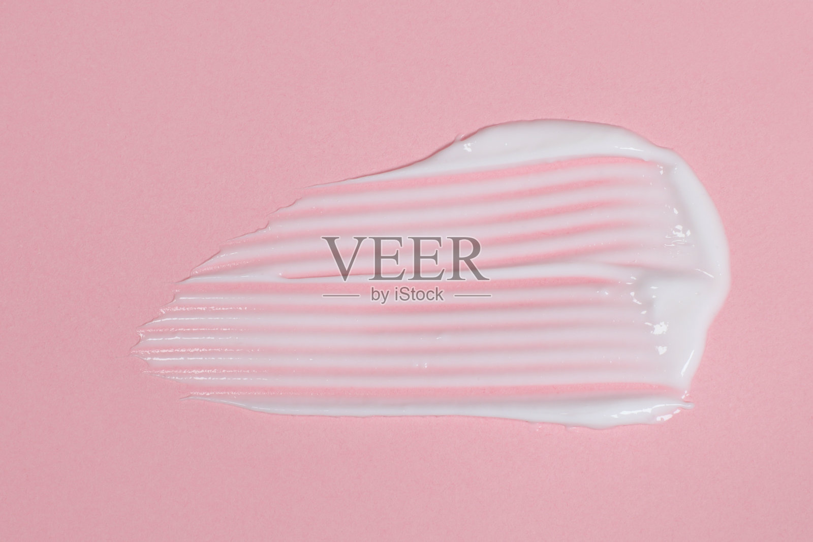 在粉红色的背景上涂抹身体或面霜照片摄影图片