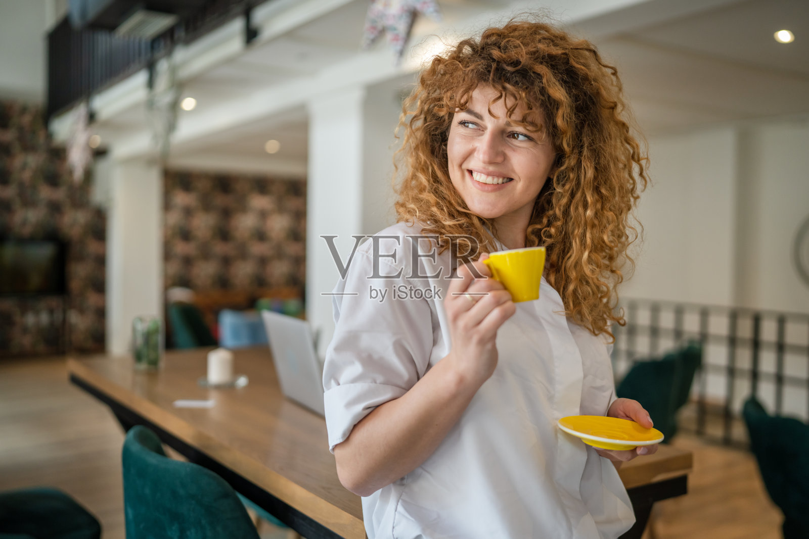 女子成年白种人女性开心地笑着在咖啡馆端着一杯咖啡照片摄影图片