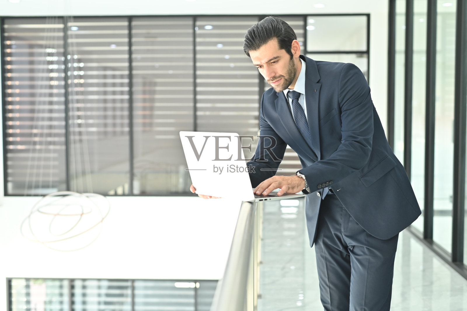 一个商人在办公室工作到很晚的时候使用笔记本电脑照片摄影图片