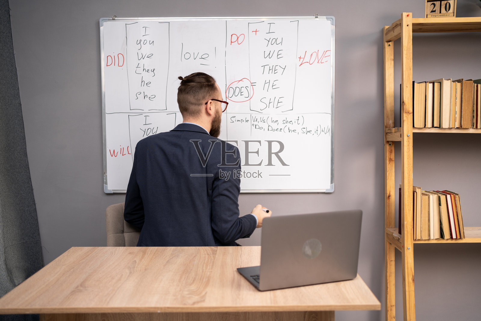 千禧一代在黑板旁解释在线英语规则。现代远程教育照片摄影图片