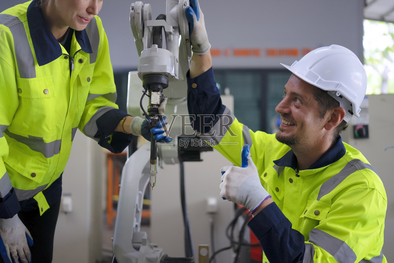 工程师在机械臂工厂工作。照片摄影图片