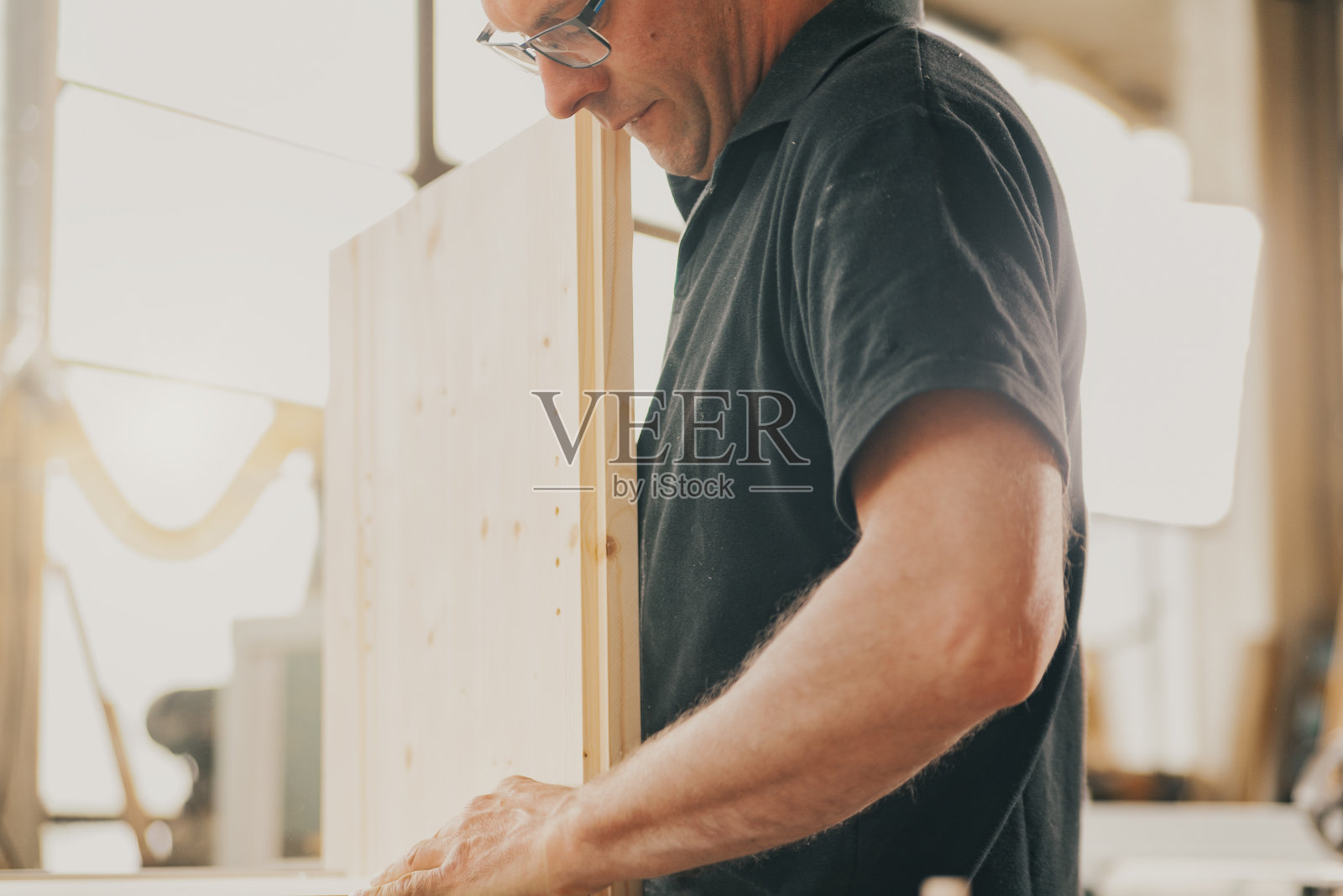 戴眼镜的木工的力量和奉献照片摄影图片