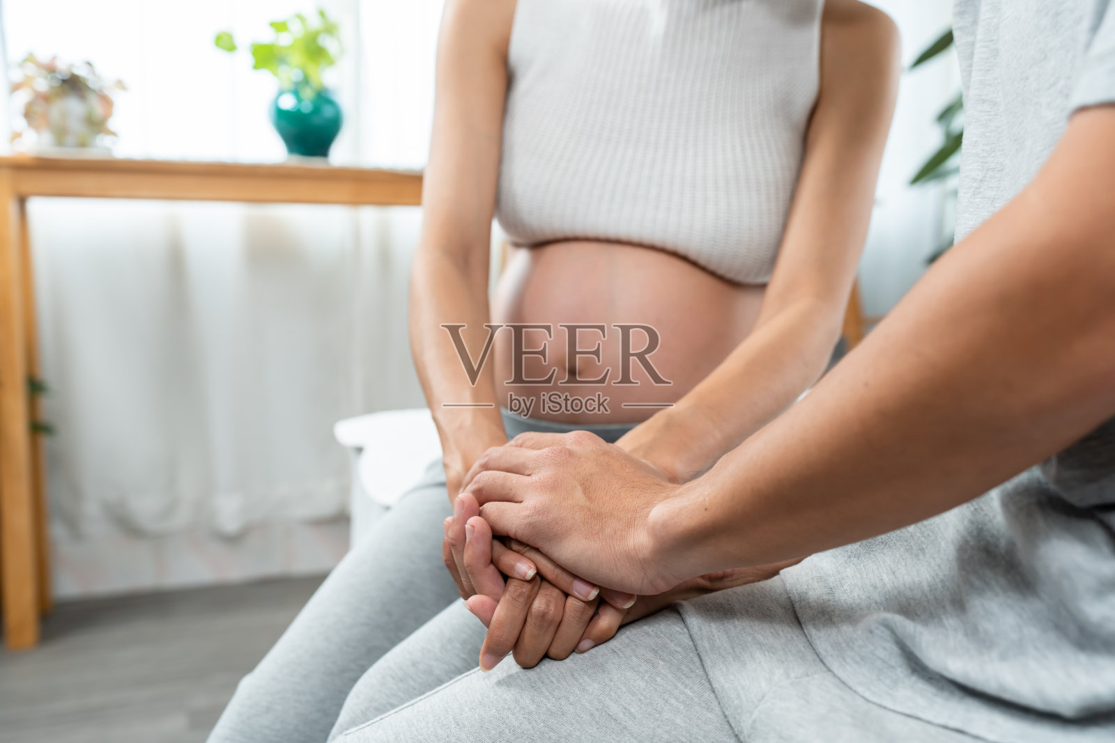 丈夫轻抚妻子手部，缓解孕期压力特写照片摄影图片