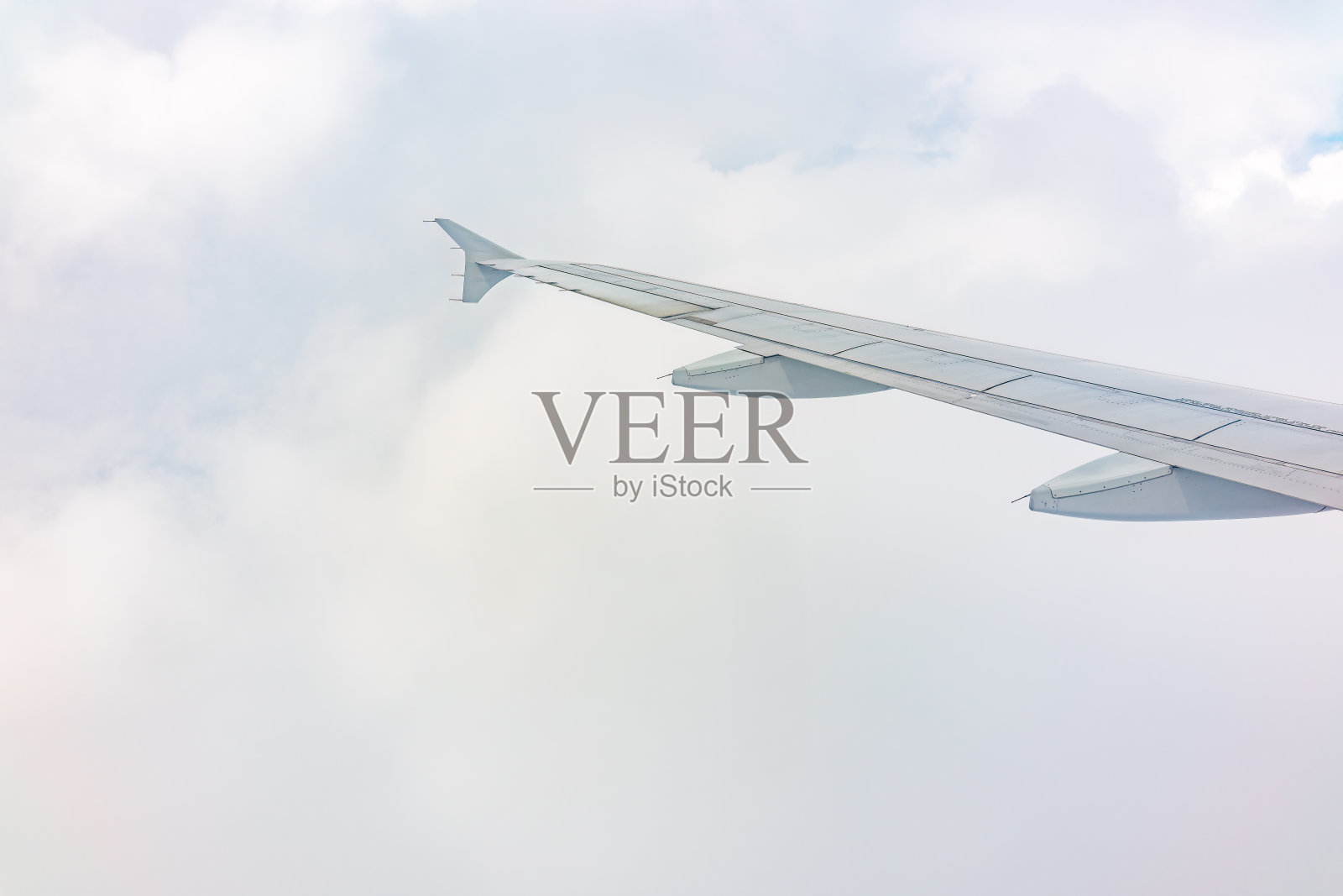 从飞机窗口看到美丽多云的天空和飞机的机翼照片摄影图片