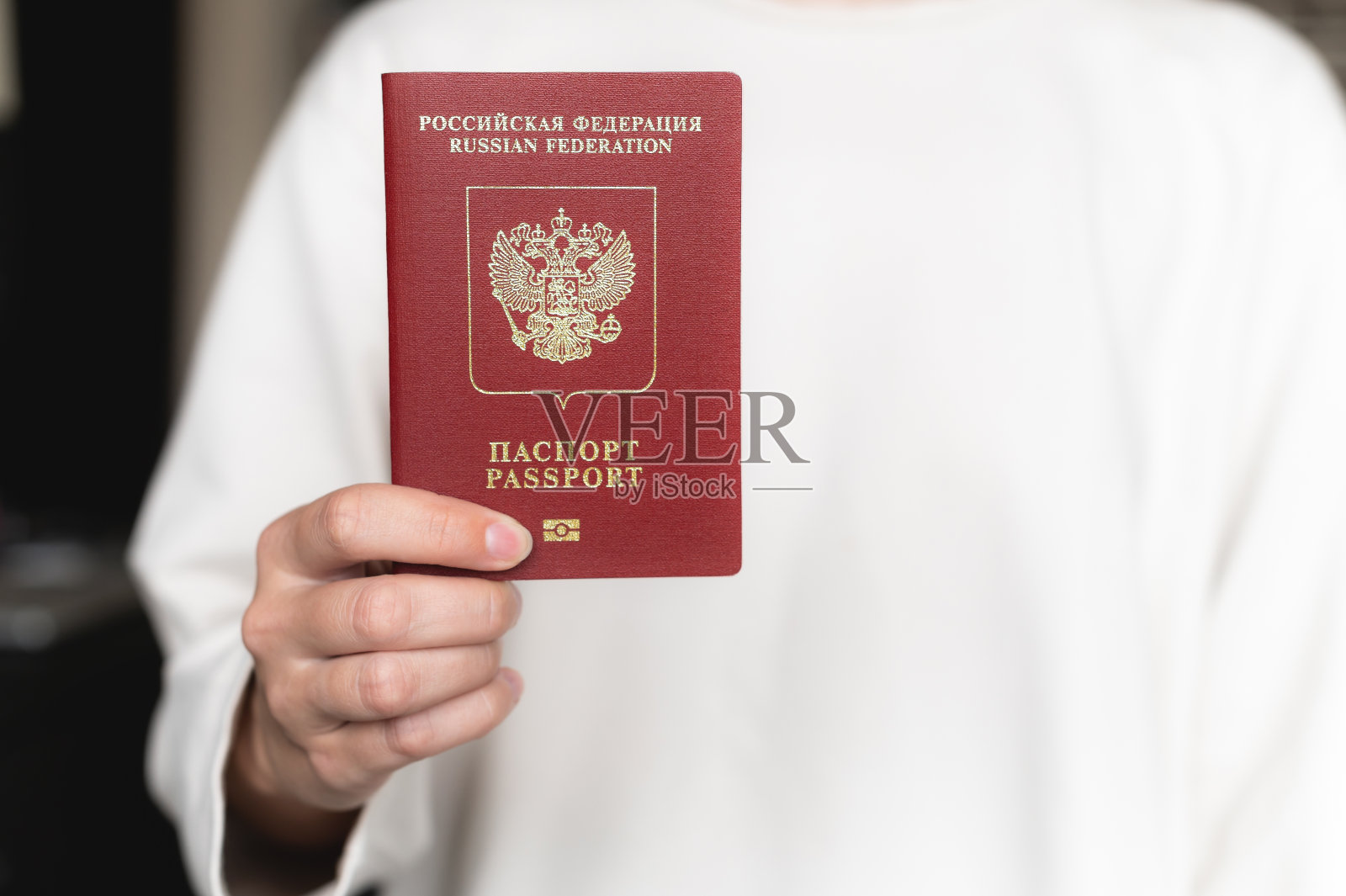 俄罗斯联邦护照。拿着俄罗斯护照的人手特写，选择性聚焦，模糊。旅游护照照片摄影图片