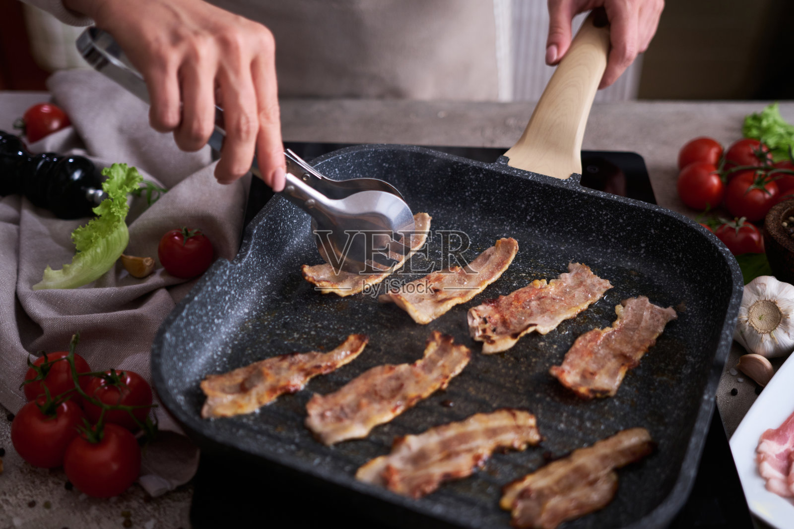 在家庭厨房的烤煎锅煎培根片照片摄影图片