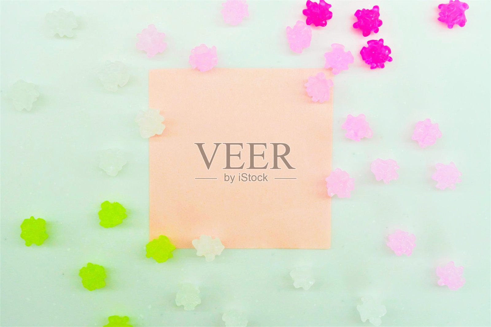 春天般的标题框架模型与粉红色和绿色彩色糖果手杖称为五彩纸屑散落在白色的背景照片摄影图片