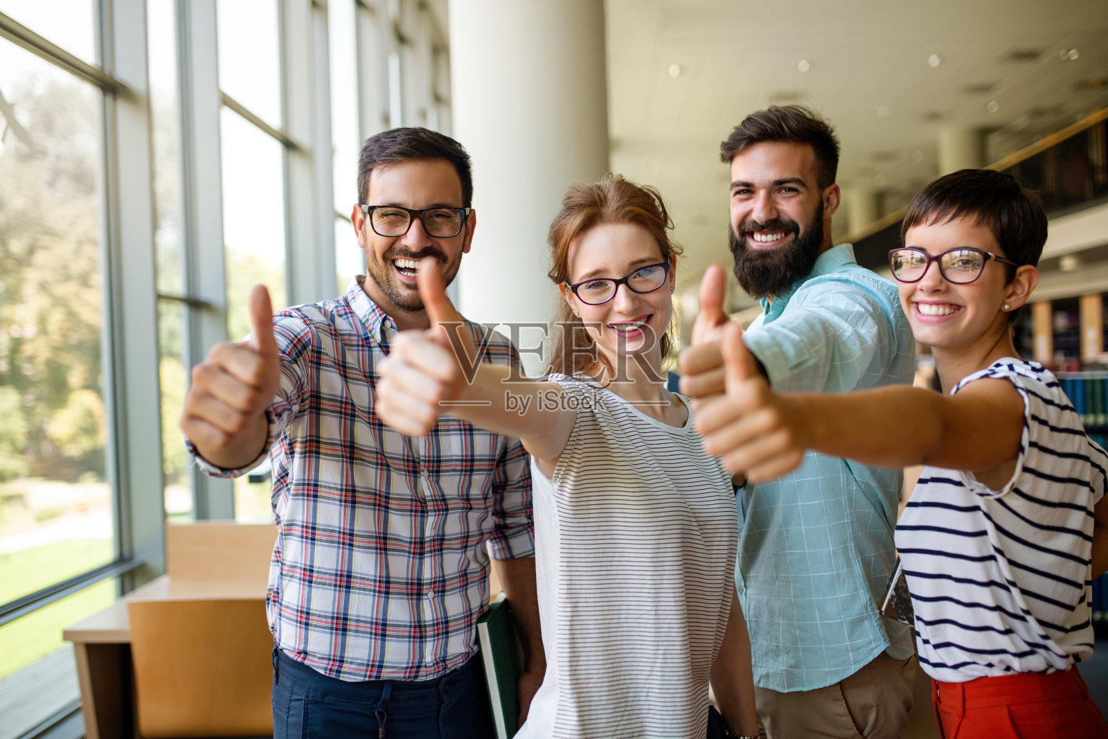 在图书馆学习的学生。年轻的成功人士花时间在一起，一起学习。照片摄影图片