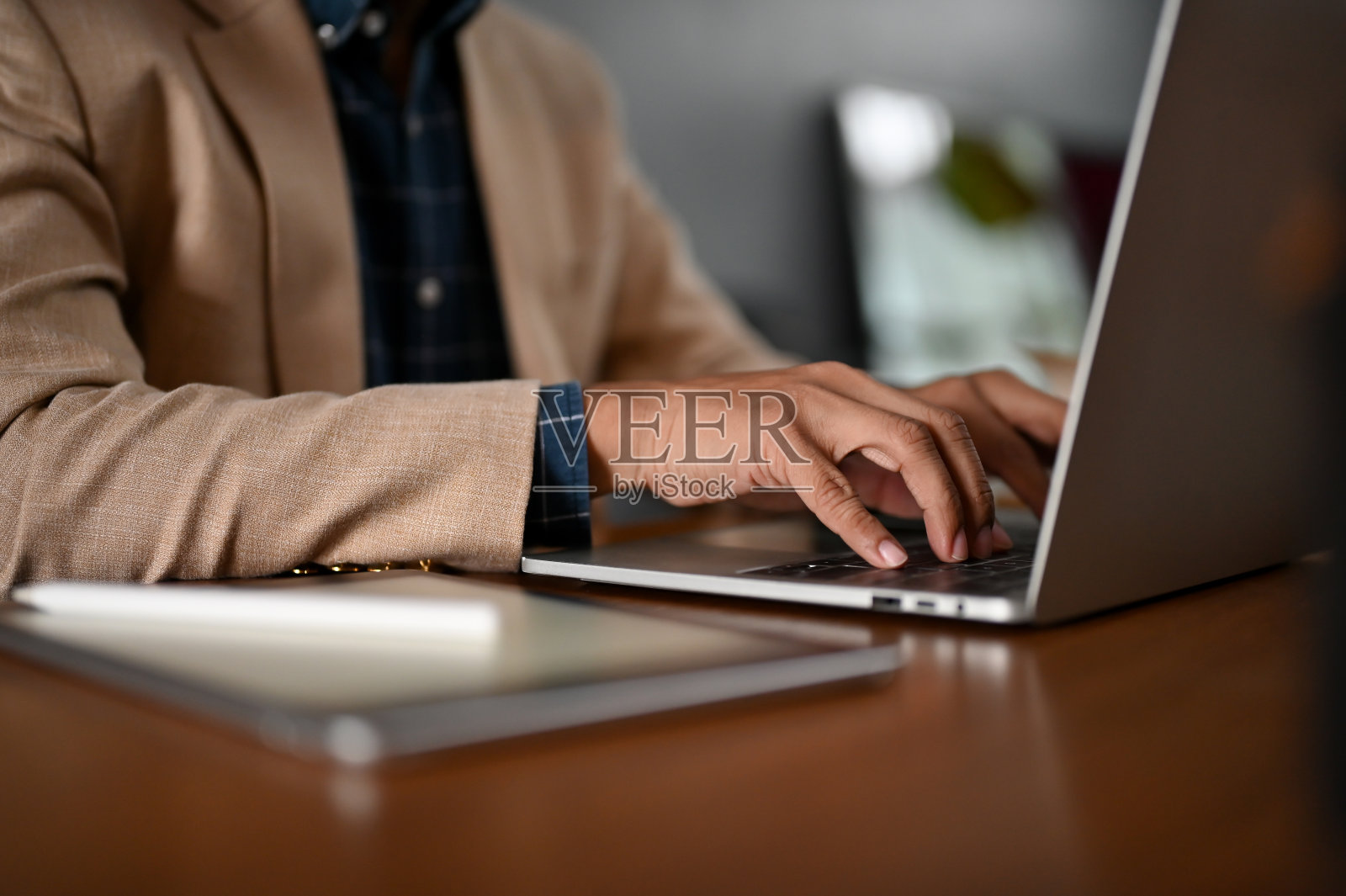 一个专业的商人在桌子上用笔记本电脑打字。照片摄影图片