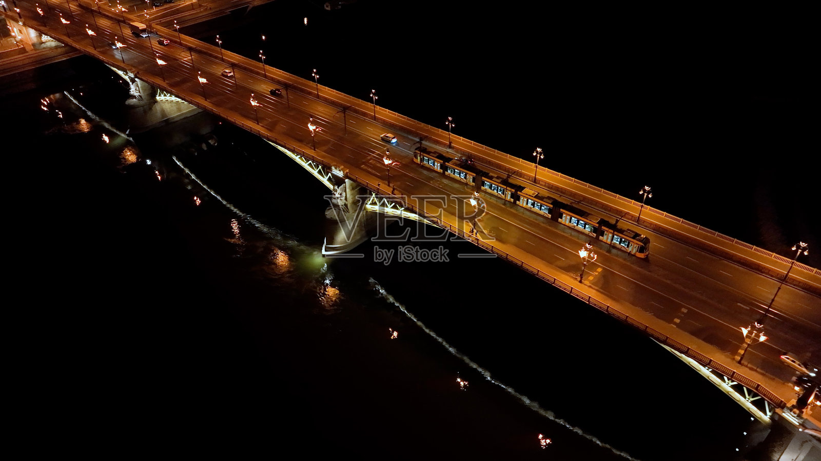 鸟瞰布达佩斯玛格丽特大桥或玛格丽特隐藏在多瑙河河堤上的夜晚。城市的公共交通。典型的黄色有轨电车穿过这座桥照片摄影图片