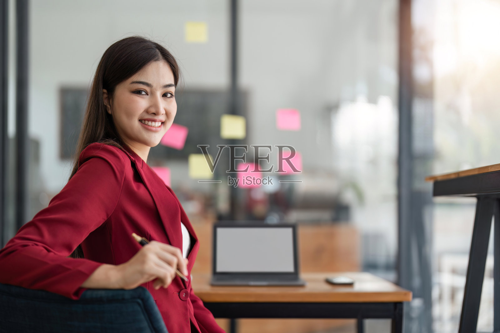 女商人微笑着在办公室工作，贴在玻璃墙上的便签，商业设计策划理念照片摄影图片