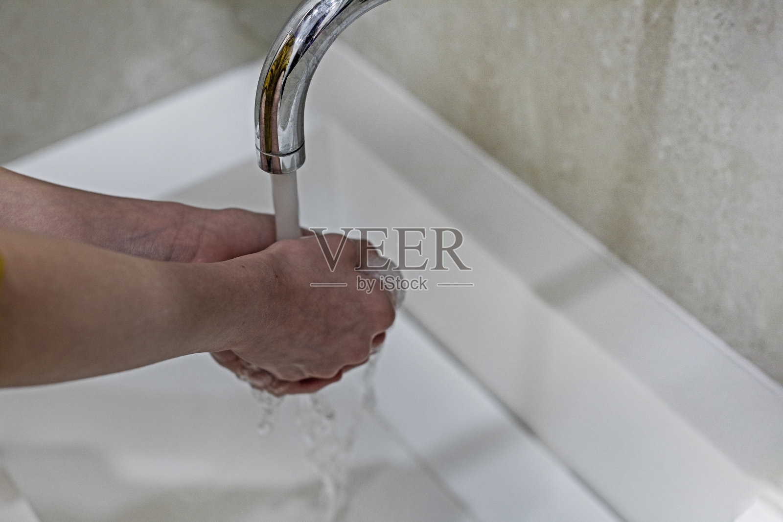 孩子在水的压力下洗手，以防感染和病毒。covid照片摄影图片