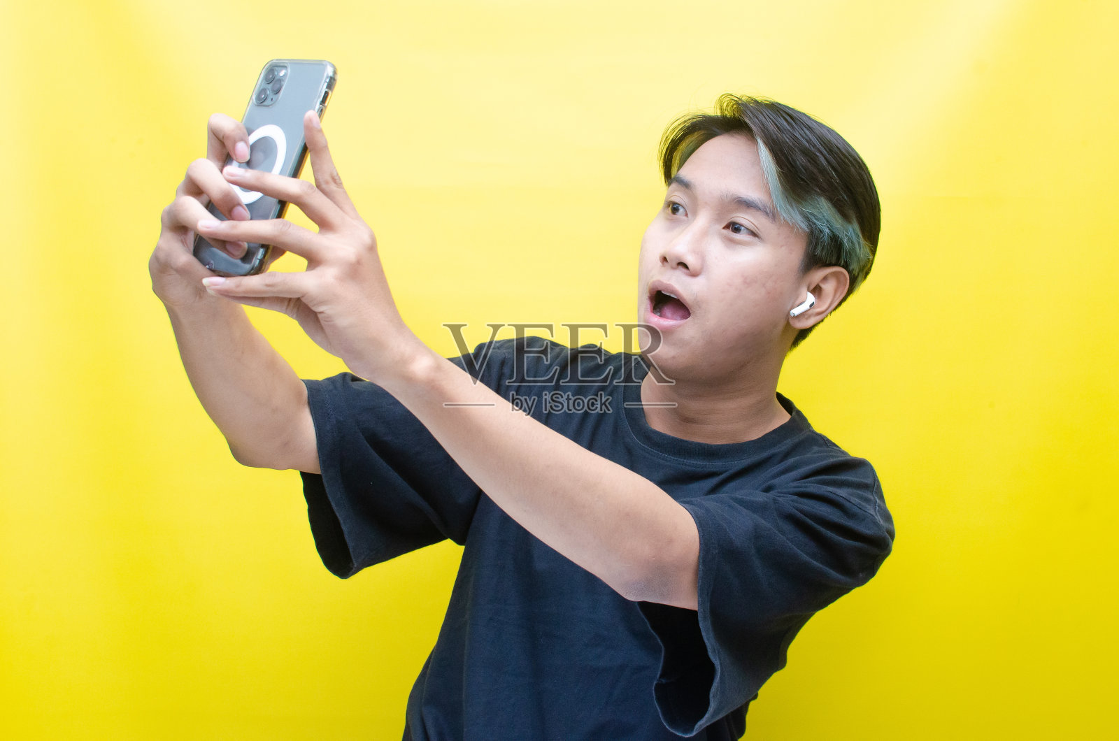 亚洲男子拿着手机用无线耳机听音乐照片摄影图片