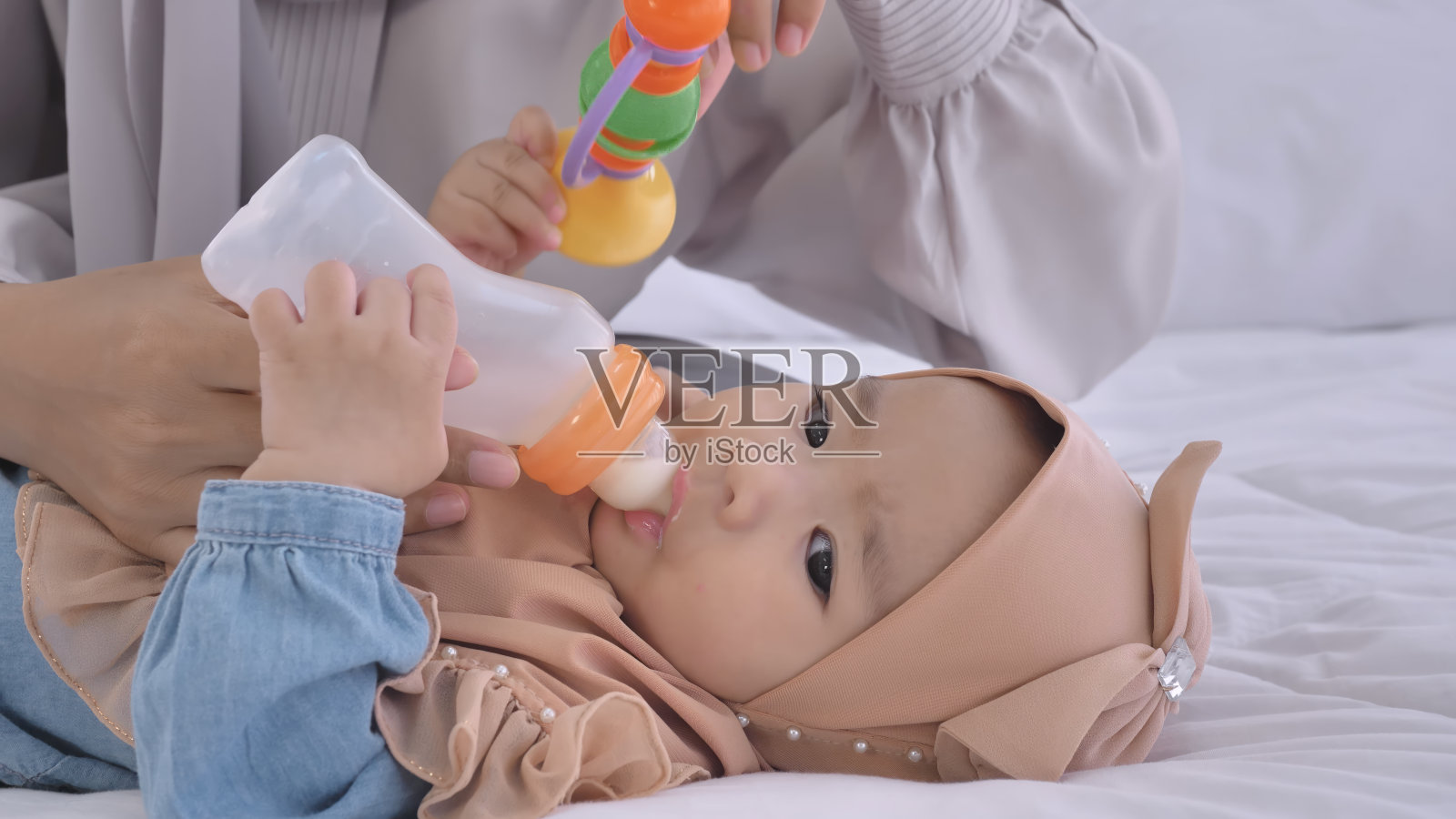 小婴儿从奶瓶里吸吮牛奶照片摄影图片