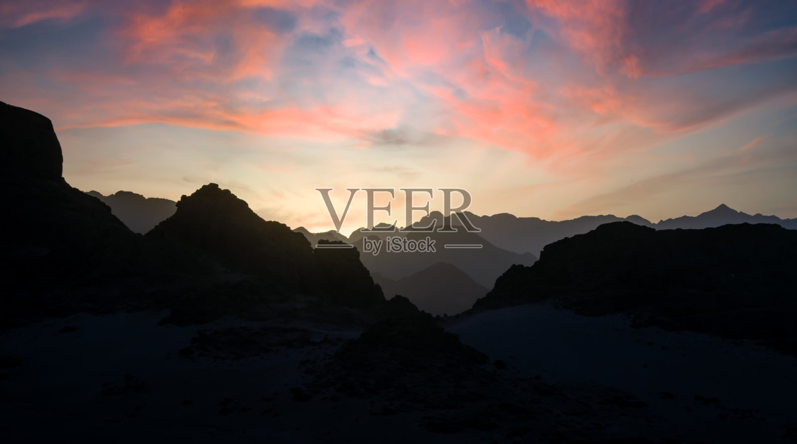 落日映衬下的沙漠中的山峰照片摄影图片