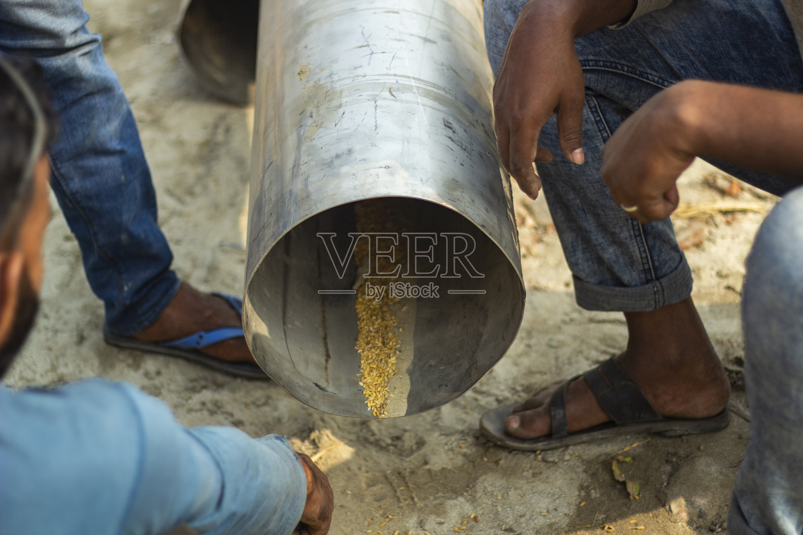 这是一个飞机座位管道，一些大米在管道里面，有人坐在管道周围。照片摄影图片