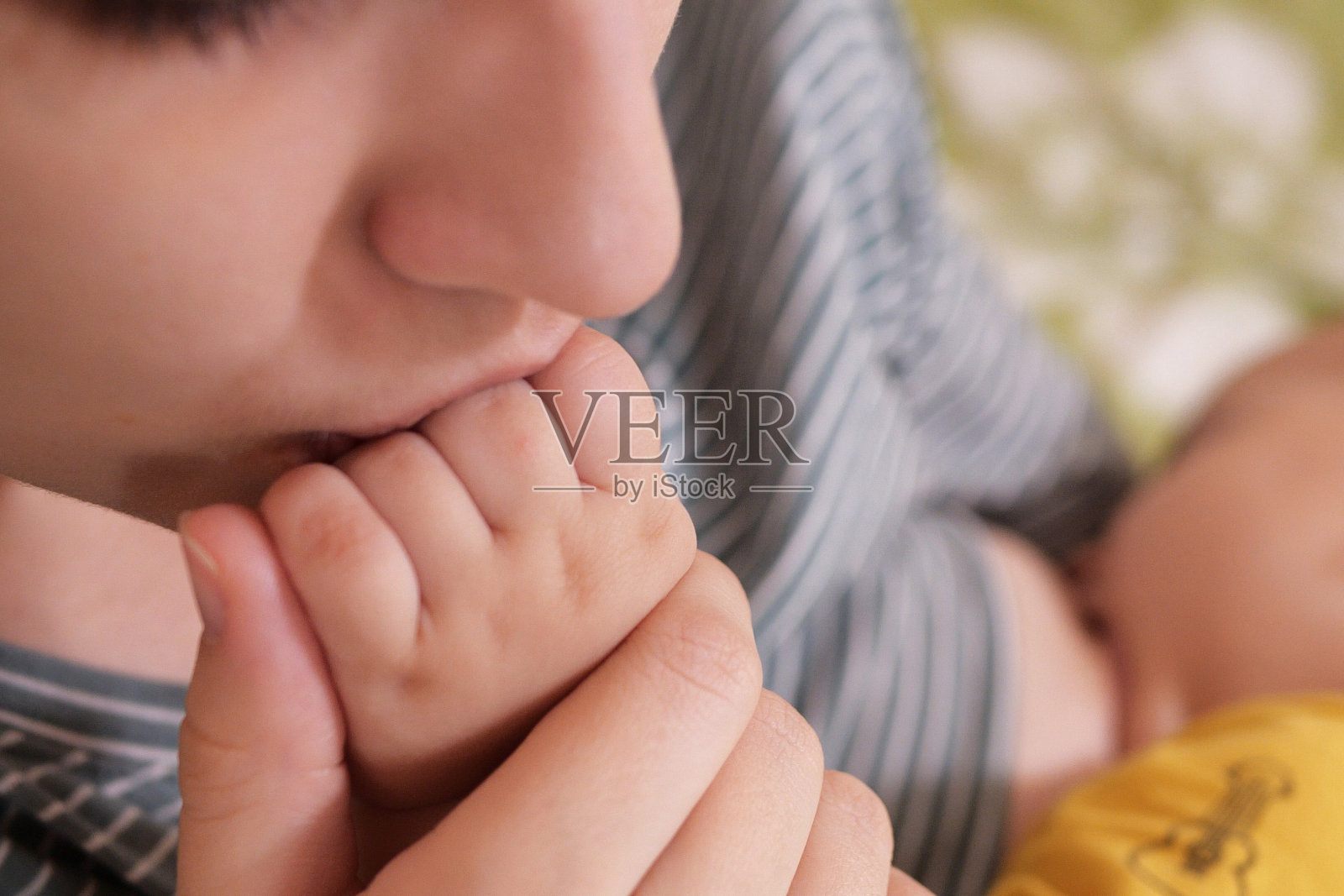 年轻妇女在家给孩子喂奶。母亲的乳汁是婴儿的天然药物。母亲节与新生儿护理的亲密概念照片摄影图片