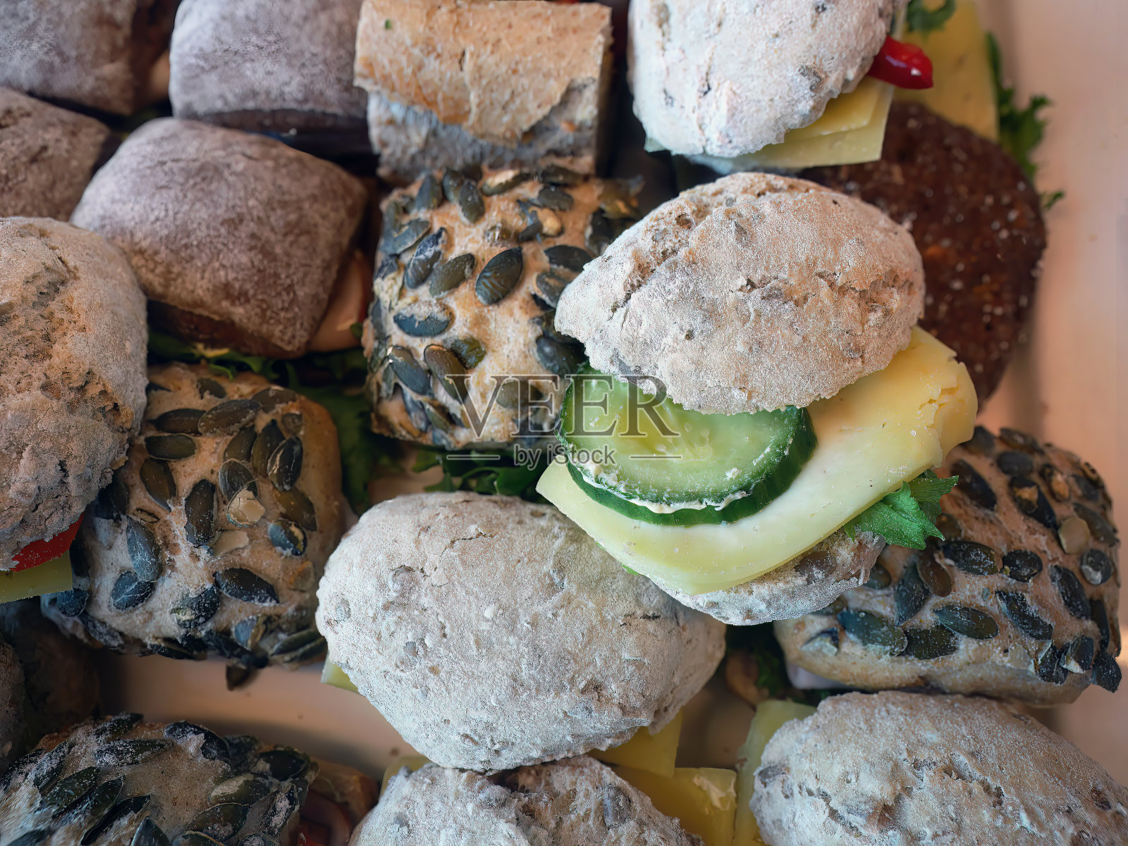 近距离拍摄各种全麦黄瓜和冷切奶酪面包、南瓜子面包、新鲜小圆面包、三明治、零食、墙纸照片摄影图片