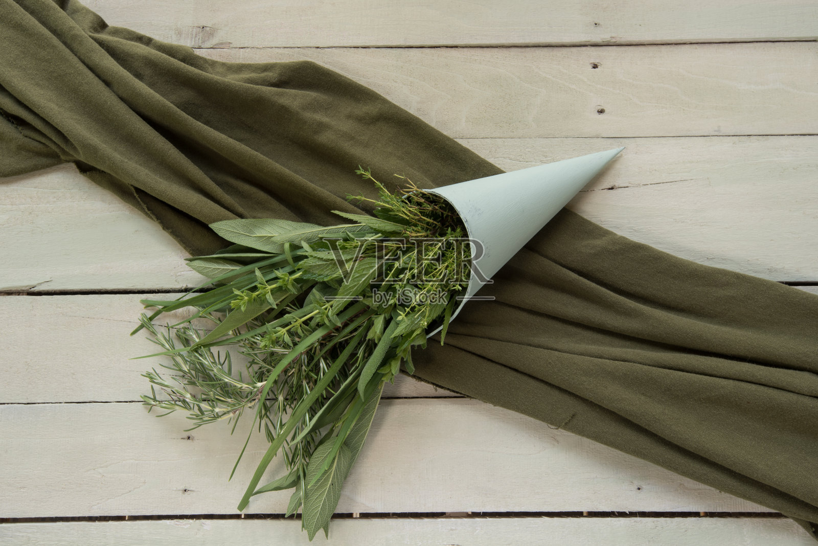 新鲜的绿色烹饪香草的气味在一个圆锥形的容器。照片摄影图片