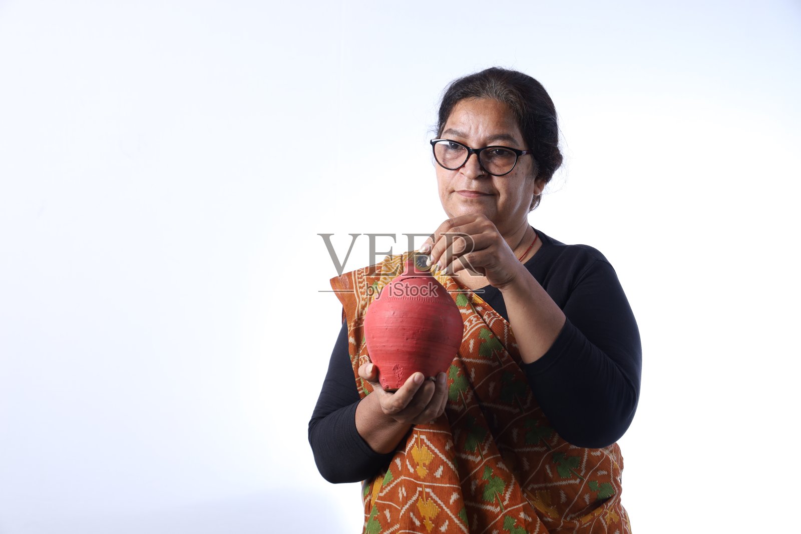 印度农村老妇人为将来存钱。存钱罐存钱的概念。照片摄影图片