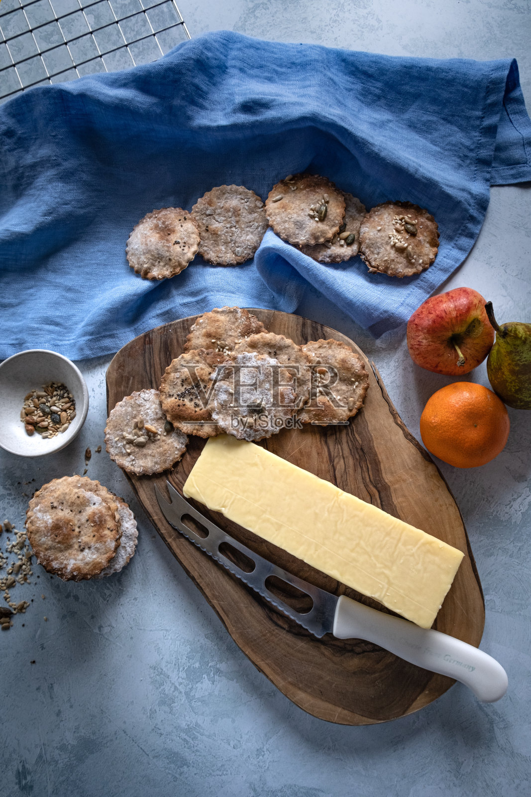 奶酪和饼干放在桌子上的木板上照片摄影图片