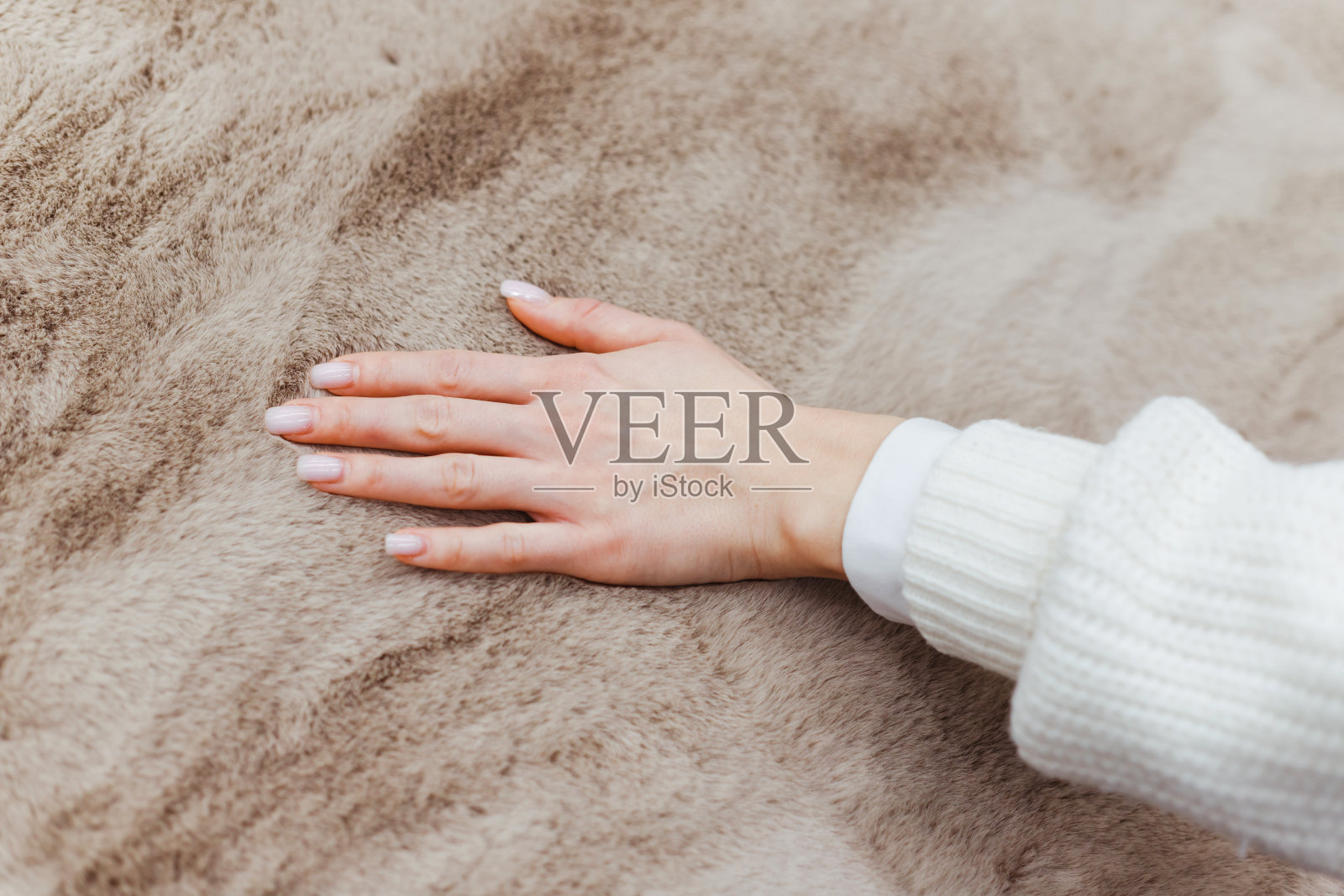 手触摸柔软地毯的特写。柔软蓬松的地毯夹在手指之间。照片摄影图片