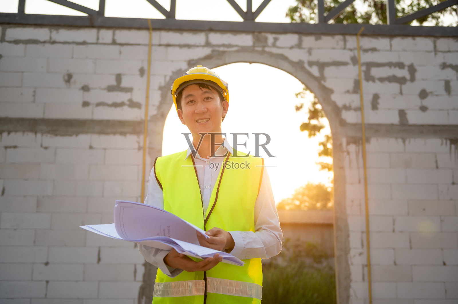 一名亚洲工程师戴着安全帽在工地分析施工图照片摄影图片