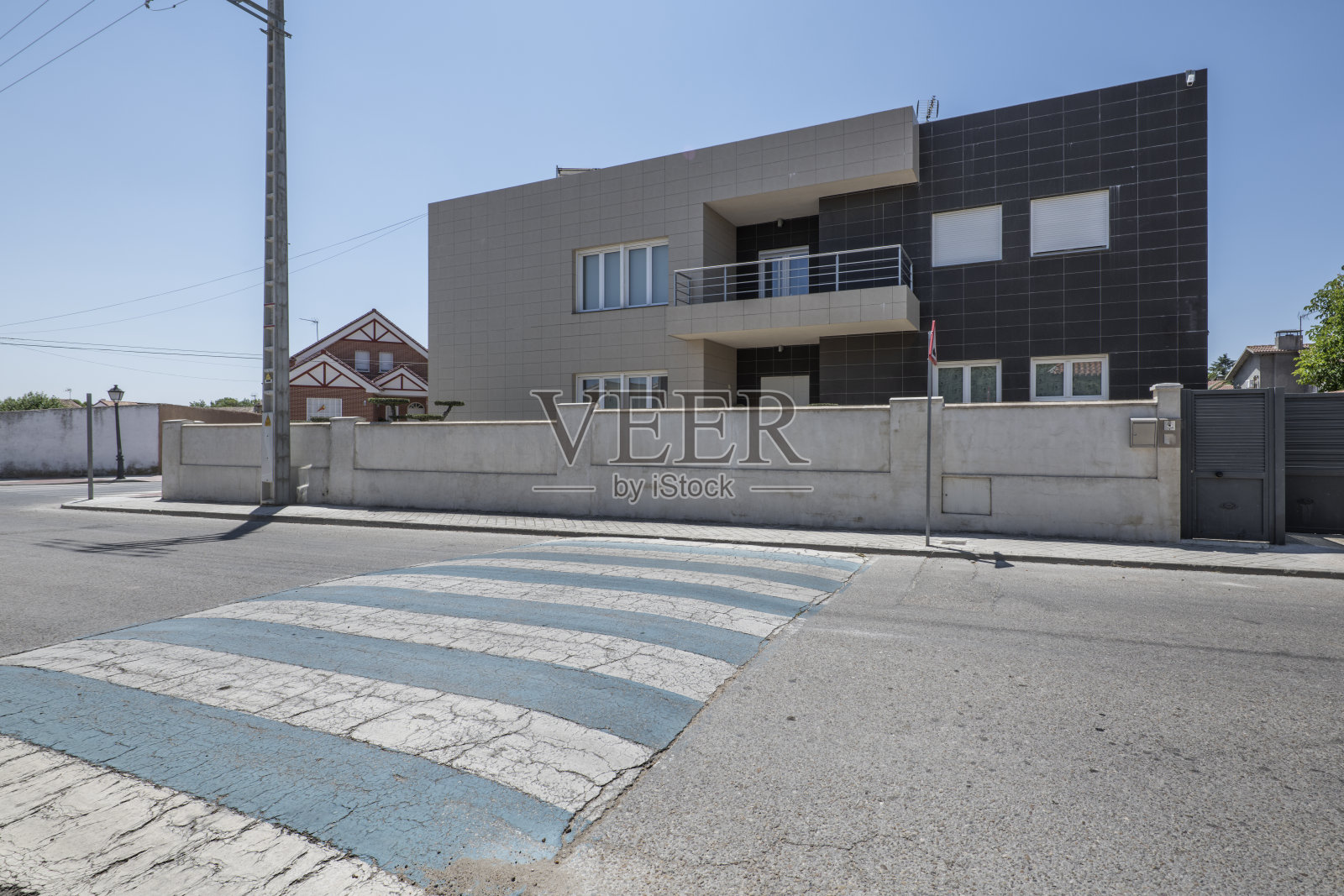 一条有斑马线的城镇街道，背景是涂成灰色的砖墙照片摄影图片