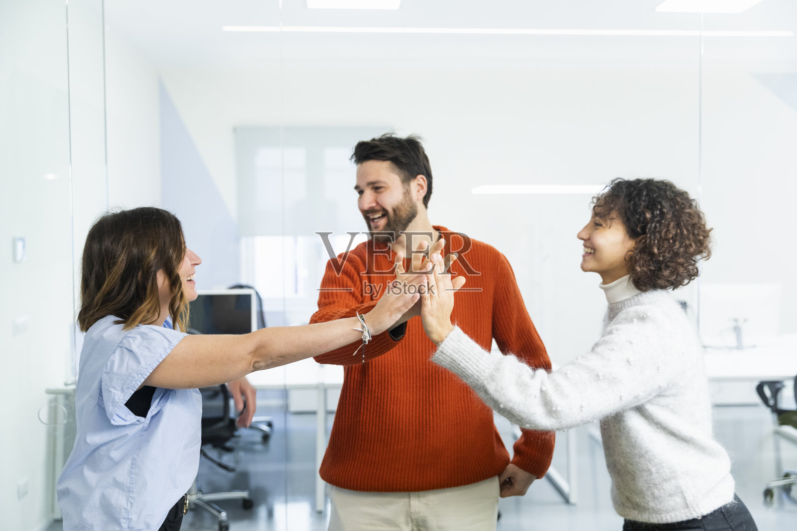 快乐的商务人士在办公室里互相击掌照片摄影图片