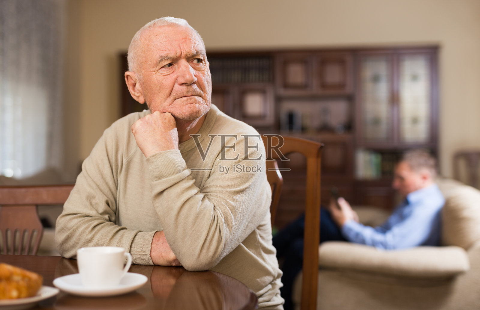 与成年儿子吵架后沮丧的老人照片摄影图片