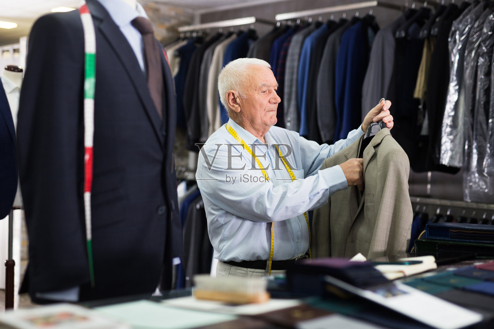 成熟的裁缝在服装店展示时装照片摄影图片