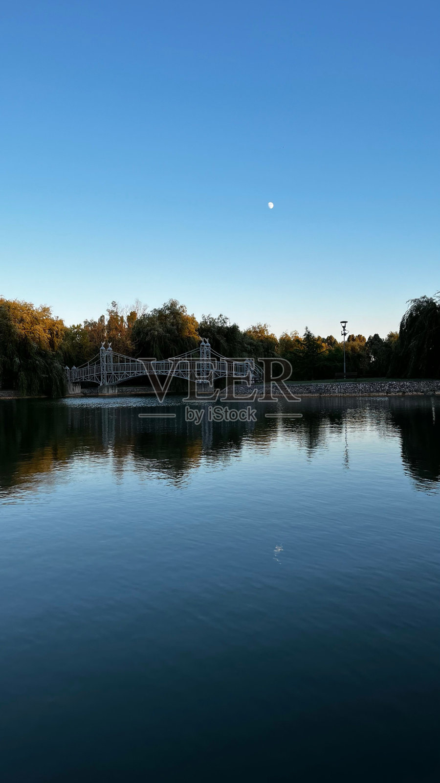 风景如画的桥梁横跨在宁静的水面上，湛蓝的天空照片摄影图片