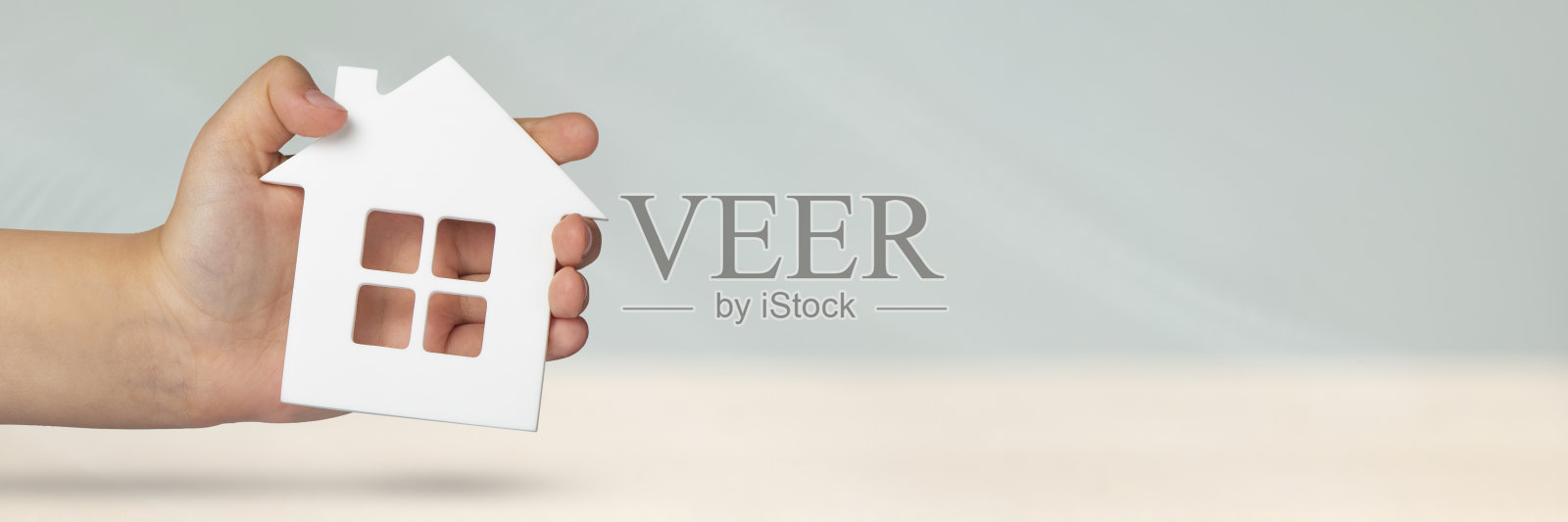 不动产保险。在灰色模糊的背景上，一个白色的房子模型。保险一套房子或公寓，概念保险服务，带有复印空间照片摄影图片